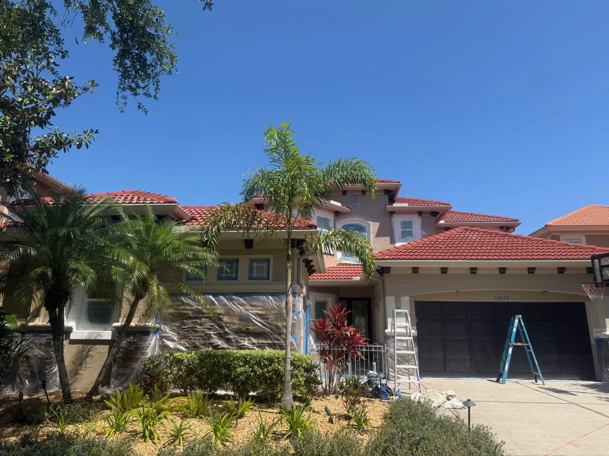 Before, faded Tampa home exterior masked off for repainting
