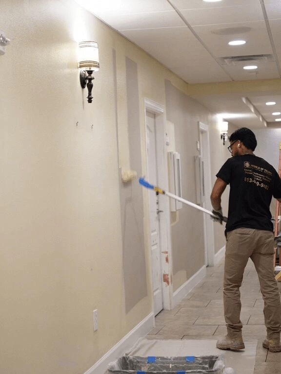 Interior painting in Tampa, crew rolling a hallway wall